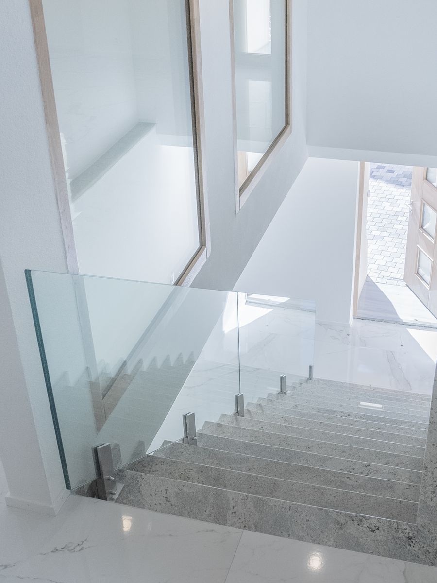 Palier en marbre avec garde-corps en verre dans une maison rénovée